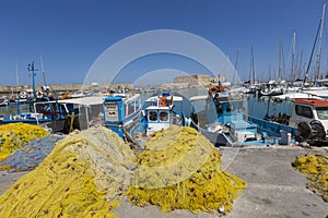 Fishing nets and fishing boats near Venetian fortress in the port of Heraklion. Crete, Greece