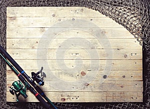 Fishing nets and fishing rod still-life on the wooden background