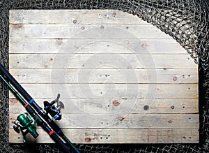 Fishing nets and fishing rod still-life on the wooden background