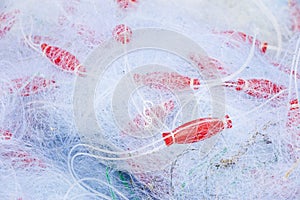 Fishing nets in a pile mixed with red floaters