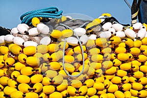 Fishing nets with yellow floats on the pile, close up