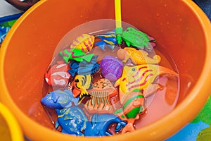 Fishing in the paddling pool. Children`s toys in the pool. Toy fish fishing rod. Cheerful children fishing, fishing in