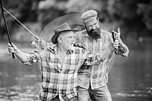 Fishing peaceful activity. Father and son fishing. Grandpa and mature man friends. Fisherman family. Rod tackle. Fishing
