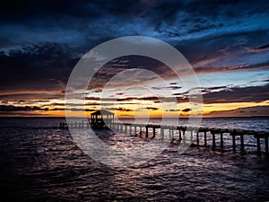 Fishing pier and dock silhouetted in a colorful sunset