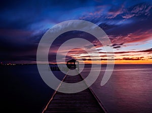 Fishing pier and dock silhouetted in a colorful sunset