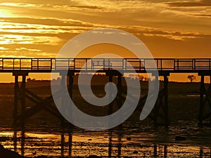 Fishing pier silhouette with sunris yellow colored sky