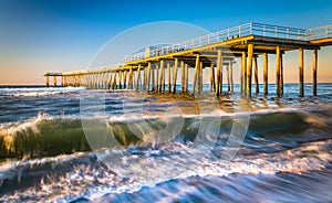 A fishing pier and waves in the Atlantic Ocean at sunrise, in Ventnor City, New Jersey.