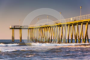 Fishing pier and waves on the Atlantic Ocean at sunrise in Ventnor City, New Jersey.