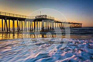 Fishing pier and waves on the Atlantic Ocean at sunrise in Ventnor City, New Jersey.