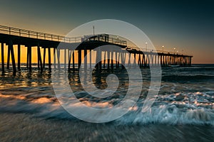 Fishing pier and waves on the Atlantic Ocean at sunrise in Ventnor City, New Jersey.