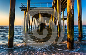 Fishing pier and waves on the Atlantic Ocean at sunrise in Ventnor City, New Jersey.