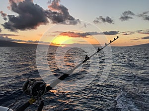 Fishing pole in the ocean waters at sunset