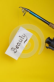 Fishing pole with paper and word BEAUTY