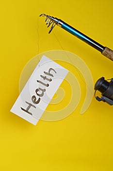 Fishing pole with paper and word HEALTH