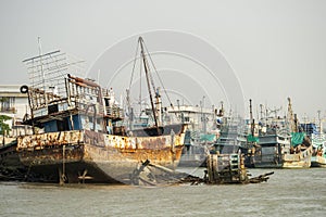 Fishing port with moored boats and some ruined on the coast of Phuket city