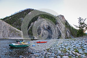 Fishing rafts and kayaks on a gravel bank on a Mongolian river canyon