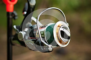 Fishing reel on a rod with a woven thread