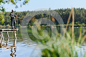 Fishing in river.A fisherman with a fishing rod on the river bank. Man fisherman catches a fish pike.Fishing, spinning reel, fish