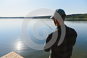 Fishing in river.A fisherman with a fishing rod on the river bank. Man fisherman catches a fish pike.Fishing, spinning reel, fish