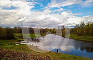 Fishing in the river. Fishermen sit with a fishing rod on the Bank of a small river. - Concept of country recreation. Article