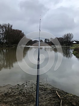 Fishing rod on the background of the river.Fisherman, fisherman, fish, nature, cloudy day, rainy weather.