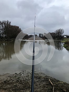 Fishing rod on the background of the river.Fisherman, fisherman, fish, nature, cloudy day, rainy weather, climate.