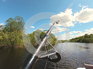 fishing rod on the background of the river and vegetation on the shore