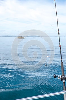 Fishing rod with bait and sinker with navigation buoy in background in Far North District, Northland, New Zealand, NZ photo