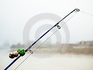 Fishing rod with bells to alert about the bite. Fishing rod in the fog on the river