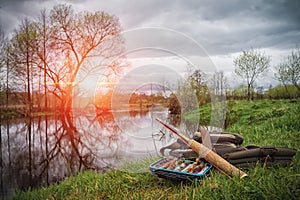 Fishing rod and box with lures on a sunset background. Tenkara