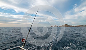 Fishing rod on charter fishing boat on the Sea of Cortes / Gulf of California viewing Lands End at Cabo San Lucas Baja Mexico