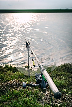 Fishing rod on the grass near the lake