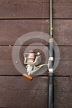 Fishing rod reel on the wooden board