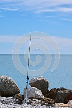 fishing rod on some rocks in the sea