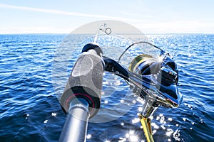 Fishing rod spinning with the line close-up. Fishing rod in rod holder in fishing boat due the fishery day. Fishing rod rings. Fis