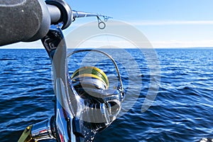 Fishing rod spinning with the line close-up. Fishing rod in rod holder in fishing boat due the fishery day. Fishing rod rings. Fis