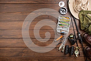 Fishing rod, tackles and other stuff for recreation activity on the wooden desk. Fishing season concept