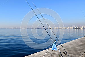 Fishing rod on Thessaloniki pier by the blue sea. View of waterfront, Thermaikos Gulf, Greece.