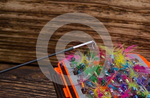 Fishing rod whip, close-up, on the background of the bait box, on a wooden background