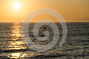 Fishing rodes  pointing at sunset on Newport Beach pier