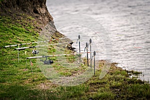 Fishing rods at the edge of a lake on the grass