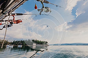 Fishing rods held in fishing rod holders, attached to a back of a boat - Image