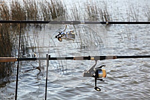 Fishing Rods at Lake with Grass and Rippled Water Background