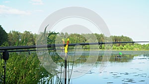 Fishing rods on the lake in summer day. Professional fishing rods waiting for bites on water river