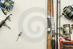 Fishing rods and reels fishing tackle on white leather background