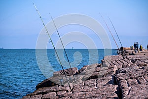 Fishing rods and reels on jetty in Port Aransas, TX at the Gulf of Mexico