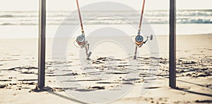 Fishing rods on the sandy beach of the ocean in a sunny summer day