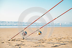 Fishing rods on the sandy beach of the sea in a summer sunny day