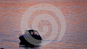 Fishing schooner at sunset, boat silhouette.