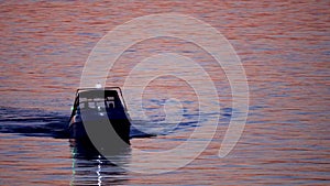 Fishing schooner at sunset, boat silhouette.